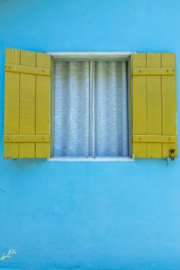 Süslü sarı pencere, mavi duvarda beyaz perde. Sap Paulo Eyaleti, Brezilya