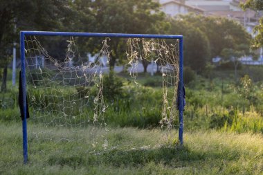 Empty soccer football net on the field in countryside of Sao Paulo state, Brazil with evening sun