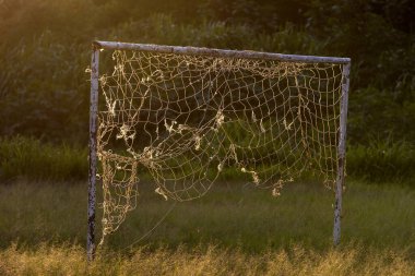 Empty soccer football net on the field in countryside of Sao Paulo state, Brazil with evening sun