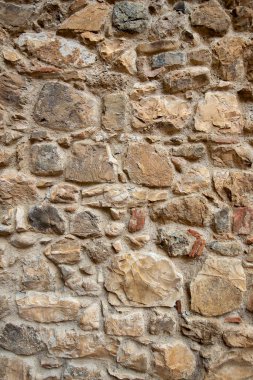 Taş duvar dokusu. Eski kale duvarı, doku arka planı. Taş duvarın bir parçası. Toskana, İtalya