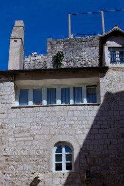 Hırvatistan 'ın eski Split kentindeki dar bir ara sokakta manzaralı orta çağ taş konut binalarının üst katlarının sokak manzarası.