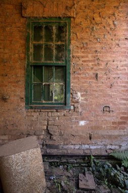 Brezilya 'nın Sao Paulo eyaletinin kırsal kesimindeki Braganca Paulista şehrinde terk edilmiş eski tarihi tren istasyonunda örümcek ağıyla örülmüş tuğla duvar ve pencere dokusu.