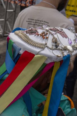 Santa Ifignia kongadasının geleneksel folklorik tezahüratında siyah erkek hatibimizin ziyafetinde kep ve kurdelelerde çok renkli süslemeler var. Sao Paulo Brezilya