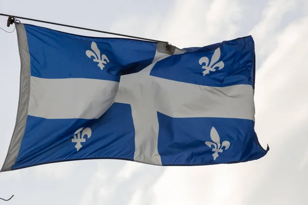 National flag of Quebec on a flagpole flutering on a wind