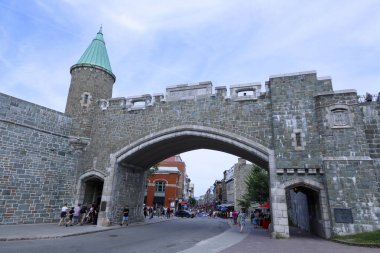 Quebec, Kanada - 12 Ağustos 2023 - Kanada 'nın Quebec şehrinin merkezindeki tarihi sağlamlaştırılmış duvarın önünde yürüyen turistler