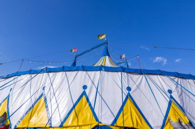 Mavi gökyüzüne karşı Brezilya, İtalya ve Sao Paulo eyalet bayrağıyla sirk çadırı, sarı ve beyaz desenli 