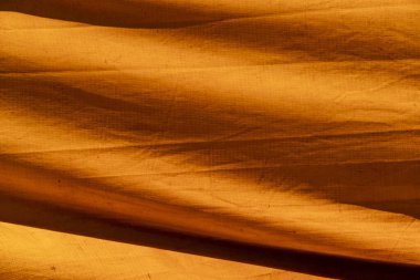 Eski sirk çadırının renkli dokusu sarı ve turuncu şekiller oluşturuyor. Tablo üzerindeki soyut yapıların bileşimi