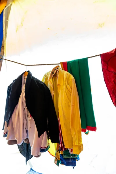 Variety of colored clothes hangers on back stage, theater or exhibition. View of a large number of different clothes on hangers.