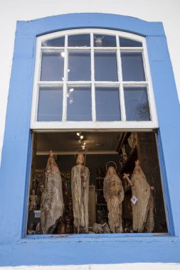 Tiradentes, Minas Gerais, Brezilya. 13 Temmuz, 2023. Tiradentes 'teki bu 18. yüzyıl penceresi şehirdeki bir zanaat atölyesinin bir parçası. Azizlerin ve diğer hatıraların resimlerinin satışı