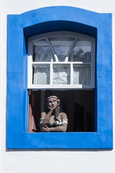 Namoradeira is a woman looking at street in the window. Brazilian handicraft made with adobe and a colonial traditional sculpture.
