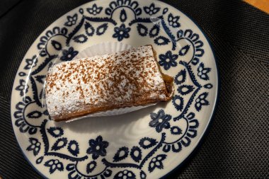 Muzlu tarçınlı kek ve üzerine şeker serpiştirilmiş mavi süslemeli bir tabak.. 