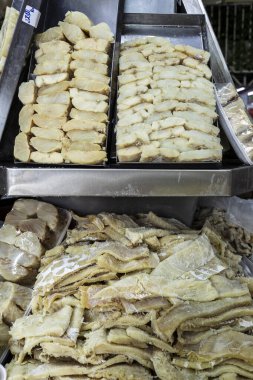 Strips of salted cod in a street market. The salting that consists of drying it with salt. clipart