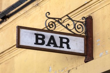 Sarı duvarda antika ve kırsal bar tabelası
