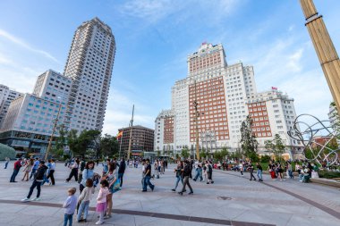 Madrid, İspanya - Nisan 07, 2024 - Madrid Plaza de Espana 'da insanlar yürür. Arkadaki bina 117 metre yüksekliğinde ve bir zamanlar İspanya 'nın en yüksek binasıydı..