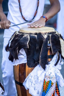 Perküsyonist atabaque, renkli dantel ve deriyle süslenmiş Afro Brezilya davulu çalar. Samba, capoeira ve candomble 'da kullanılır.. 