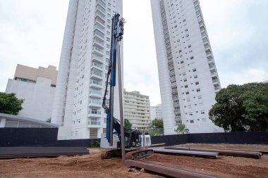 İnşaat alanında çok güçlü hidrolik sondaj kulesi var. Delme yoluyla sıkılmış yığınların kurulumu. Yığın vakıfları. Toprağı eşeliyorlar.