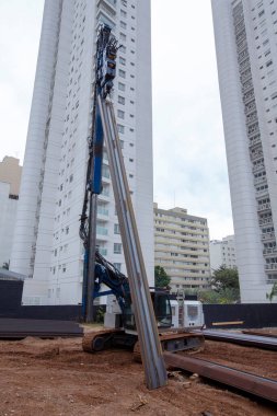 İnşaat alanında çok güçlü hidrolik sondaj kulesi var. Delme yoluyla sıkılmış yığınların kurulumu. Yığın vakıfları. Toprağı eşeliyorlar.