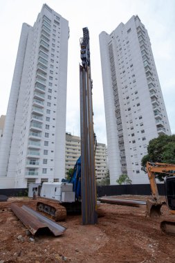 İnşaat alanında çok güçlü hidrolik sondaj kulesi var. Delme yoluyla sıkılmış yığınların kurulumu. Yığın vakıfları. Toprağı eşeliyorlar.