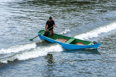 Pereque Sahili, Guaruja, Sao Paulo Eyaleti, Brezilya - Mayıs 2003, 2025 - balıkçı teknesinde kürek çekiyor ve bir günlük balık avından sonra sahile gidiyor.