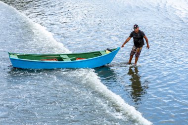 Pereque Sahili, Guaruja, Sao Paulo Eyaleti, Brezilya - Mayıs 2003, 2025 - balıkçı teknesinde kürek çekiyor ve bir günlük balık avından sonra sahile gidiyor.