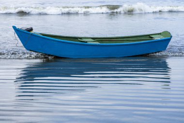 Sao Paulo, Brazi eyaletinin Guaruja sahilindeki Pereque sahilinde küçük mavi bir balıkçı teknesi.