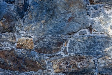 Kabataslak desenli taş duvar, çatlak yüzey. Kaya dokusunun arka planı. Sert kayalık desen. Taş yapı duvar kağıdı. 