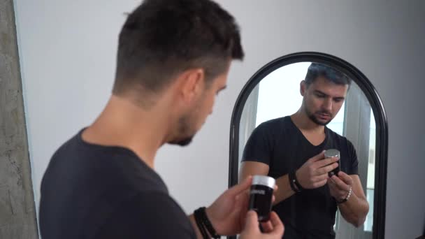ウクライナのキエフ 2022年11月7日 鏡の前の男が髪をスタイリングしています 男性用化粧品 鏡の前に若いハンサムな男が現れ — ストック動画
