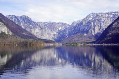 Hallstatt, Hallstetter Gölü, Avusturya - Mart 2023: Şehir manzarası güzel. Mountain Gölü. Dağların arasındaki göl. Orman gölü yakınlarındaki dağlarda kulübeler..