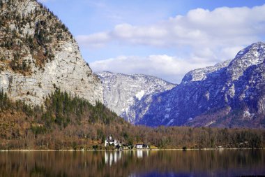 Hallstatt, Hallstetter Gölü, Avusturya - Mart 2023: Şehir manzarası güzel. Mountain Gölü. Dağların arasındaki göl. Orman gölü yakınlarındaki dağlarda kulübeler..