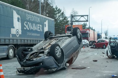 Kyiv bölgesi, Ukrayna - 10 Nisan 2023: Kente yaklaşım sırasında otoyolda devrilen araba. Otobanda bir trafik kazası. Otoyolda arabaları çarpıp devirdiler. Bir polis bir trafik kazasını inceliyor..
