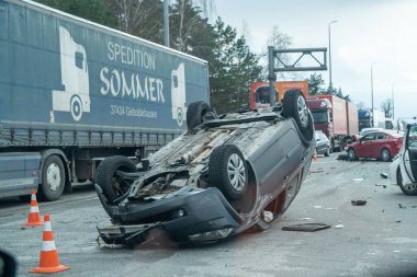 Kyiv bölgesi, Ukrayna - 10 Nisan 2023: Kente yaklaşım sırasında otoyolda devrilen araba. Otobanda bir trafik kazası. Otoyolda arabaları çarpıp devirdiler. Bir polis bir trafik kazasını inceliyor..