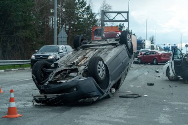 Kyiv bölgesi, Ukrayna - 10 Nisan 2023: Kente yaklaşım sırasında otoyolda devrilen araba. Otobanda bir trafik kazası. Otoyolda arabaları çarpıp devirdiler. Bir polis bir trafik kazasını inceliyor..
