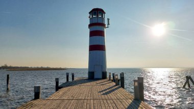 Neusiedl, Podersdorf am See, Burgenland, Avusturya - Mart 2023: Deniz feneri manzaralı, ahşap iskele.