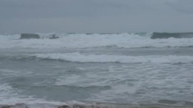 Praia do Magoito, Sintra, Portekiz - Mart 2023: Okyanus manzarası, kayalar, kum ve dalgalar sahilde. Atlantik Okyanusu.