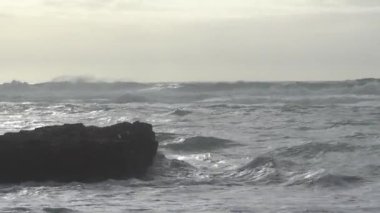 Praia do Magoito, Sintra, Portekiz - Mart 2023: Okyanus manzarası, kayalar, kum ve dalgalar sahilde. Atlantik Okyanusu.