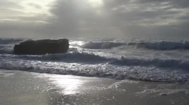 Praia do Magoito, Sintra, Portekiz - Mart 2023: Okyanus manzarası, kayalar, kum ve dalgalar sahilde. Atlantik Okyanusu.