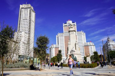 Madrid, İspanya - Mart 2023: Plaza de Espania manzarası. Meydandaki anıtın önündeki insanlar. Cervantes Anıtı