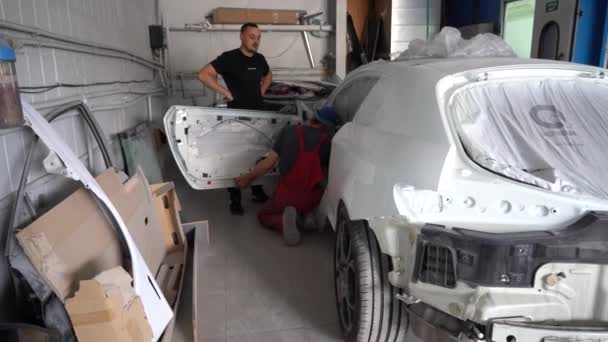 乌克兰基辅 2023年8月12日 汽车加油站的油漆店 油漆店老板 在油漆间里画一辆汽车油漆后拆开的汽车 — 图库视频影像