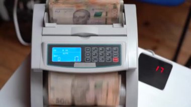 Banknotlar için sayma makinesi. Ukrayna parası bir hesap makinesinde. Ukrayna para biriminin dönüştürülmesi. Ukrayna parası banknotlar için bir makine tarafından sayılır. Ukrayna Hryvnia 'sı.
