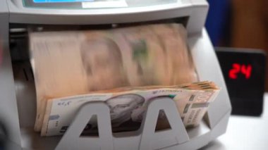 Banknotlar için sayma makinesi. Ukrayna parası bir hesap makinesinde. Ukrayna para biriminin dönüştürülmesi. Ukrayna parası banknotlar için bir makine tarafından sayılır. Ukrayna Hryvnia 'sı.