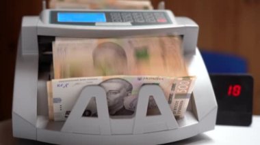Banknotlar için sayma makinesi. Ukrayna parası bir hesap makinesinde. Ukrayna para biriminin dönüştürülmesi. Ukrayna parası banknotlar için bir makine tarafından sayılır. Ukrayna Hryvnia 'sı.