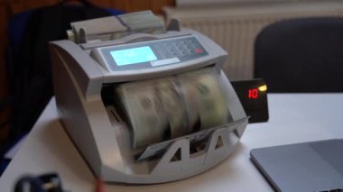Banknotlar için sayma makinesi. Ukrayna banknot sayma makinesi. Amerikan parası sayım makinesinde. Para birimi dönüşümü. Amerikan dolarları bir banknot makinesi tarafından sayılır. Bir yığın yüzlük.