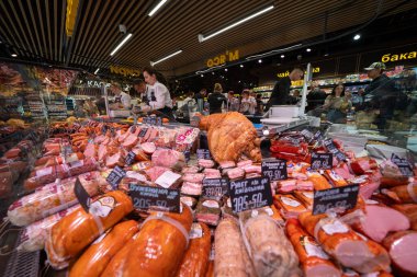 Ukraine, Bila Tserkva, Kyiv region - May 01, 2024: Customers buy food products in a store. Showcases with meat and sausage in a grocery store. clipart