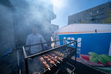 Ukrayna, Bila Tserkva, Kyiv Bölgesi - 01 Mayıs 2024: Bir adam ızgarada barbekü hazırlıyor.