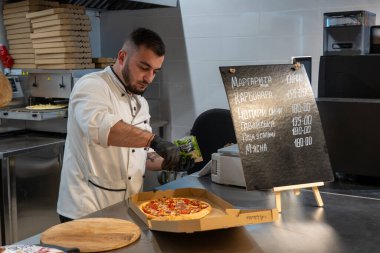 Ukrayna, Bila Tserkva, Kiev bölgesi - 01 Mayıs 2024: Bir markette pizza pişirmek. Bir pizzacı pizza hazırlar..