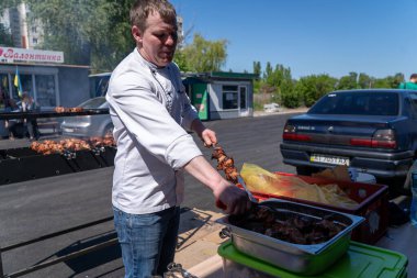 Ukrayna, Bila Tserkva, Kyiv Bölgesi - 01 Mayıs 2024: Bir adam ızgarada barbekü hazırlıyor.