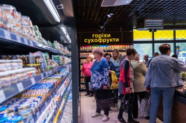 Ukrayna, Bila Tserkva, Kiev bölgesi - 01 Mayıs 2024: Bir markette gıda ürünleri içeren kasaları göster. İnsanlar bakkaldan alışveriş yapıyor..