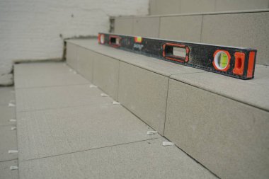 Kyiv, Ukrayna - 6 Temmuz 2021: Bir işçi basamaklara yeni fayanslar serer. Yeni döşemeler döşeniyor.