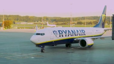 Krakow, Polonya - 20 Ekim 2024 Krakow Havaalanı. Kalkıştan önce uçak kontrolleri (biniş). Havaalanı çalışanı uçağa servis yapıyor. Bagaj yükleme (boşaltma). Yolcular (varış). Ryanair