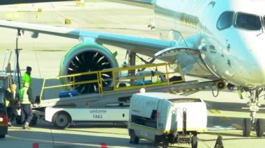 Krakow, Polonya - 20 Ekim 2024 Krakow Havaalanı. Kalkıştan önce uçak kontrolleri (biniş). Havaalanı çalışanı uçağa servis yapıyor. Bagaj yükleme (boşaltma). Yolcular (varış). Ryanair